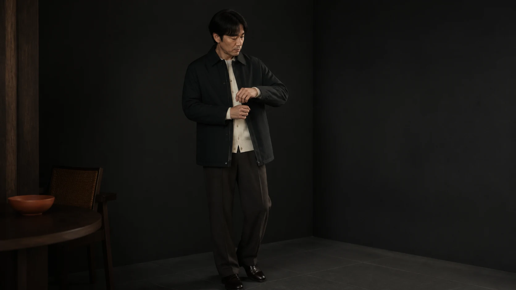 카디건 위 재킷을 입고 팔을 움직이며 어깨와 앞여밈, 소매 겹침을 확인하는 남성