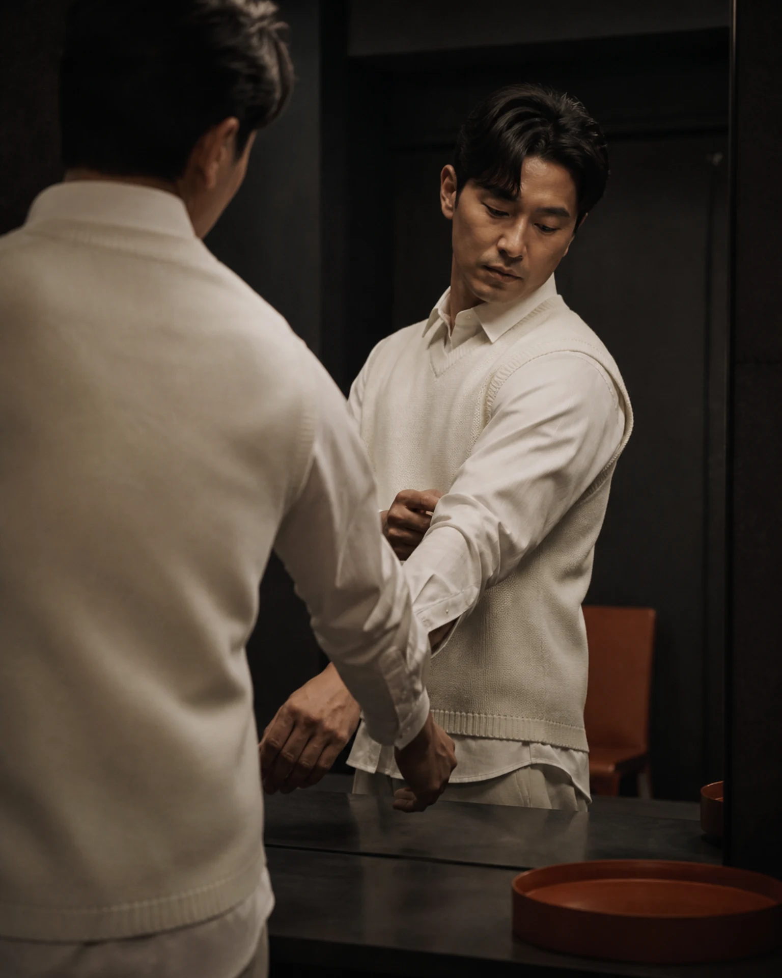 셔츠 위에 니트 베스트를 입고 암홀과 밑단, 팔 움직임을 확인하는 남성