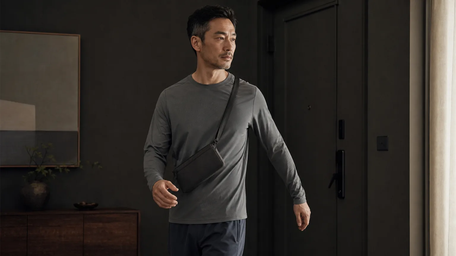 운동복 차림으로 팔 움직임과 작은 가방의 위치를 확인하는 남성