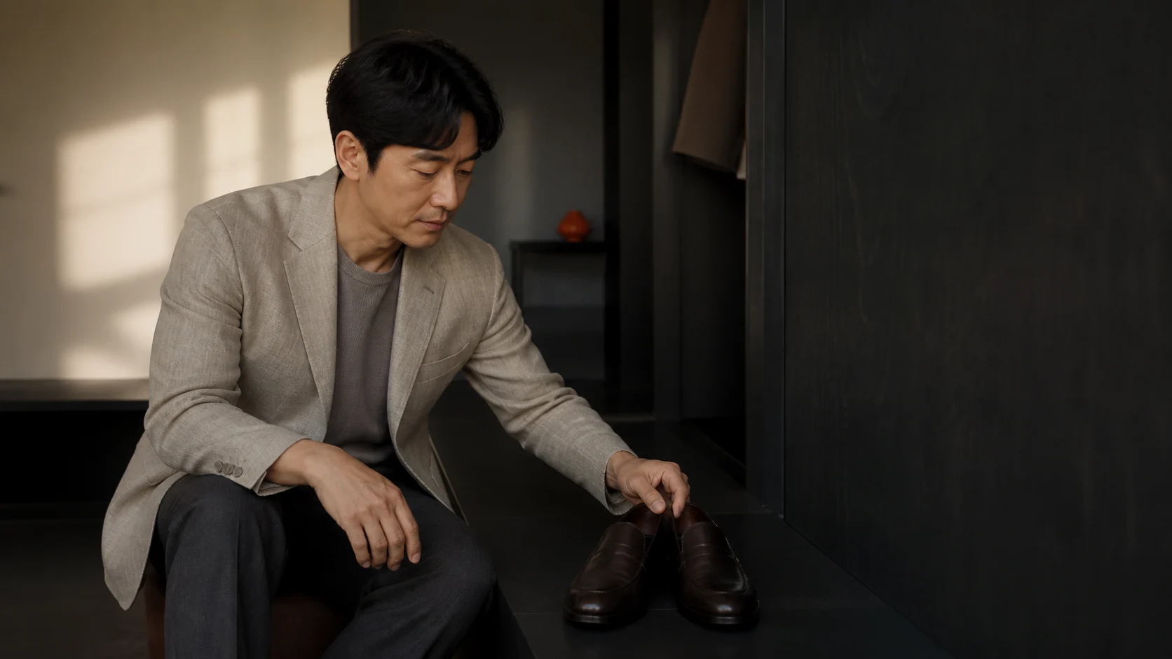 블레이저와 팬츠 차림에 맞춰 신발 한 켤레를 비교하는 남성