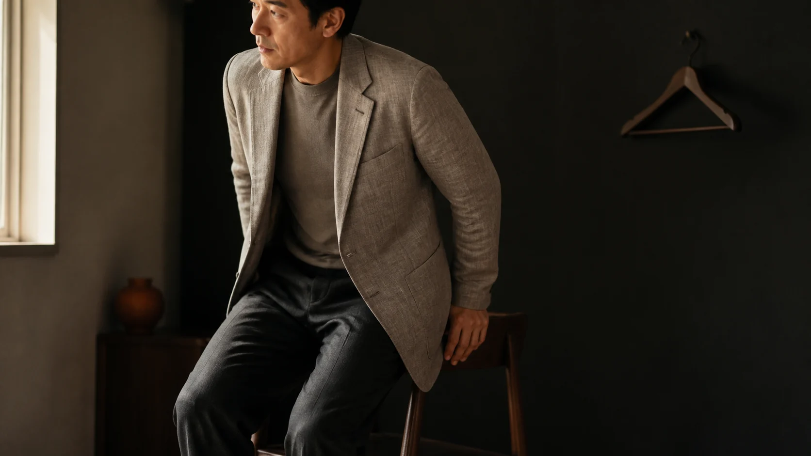 블레이저를 입고 앉았다 일어서며 움직임과 다음 행동을 확인하는 남성