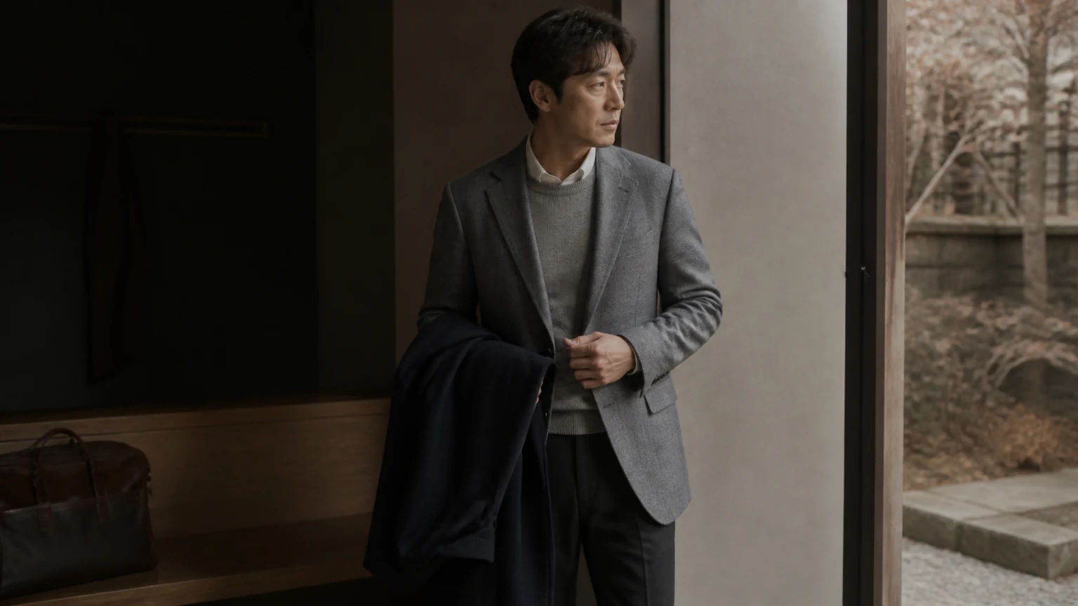 아우터를 벗어 들고 실내외 전환을 준비하는 남성